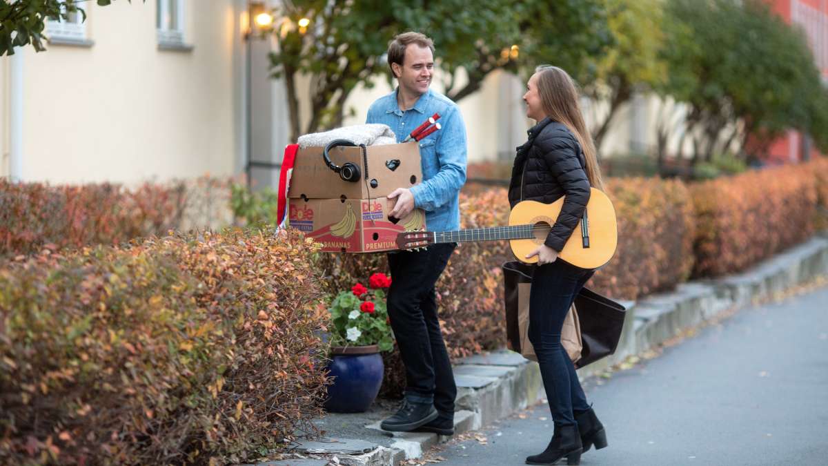 Mand og kvinde bærer en æske og en guitar